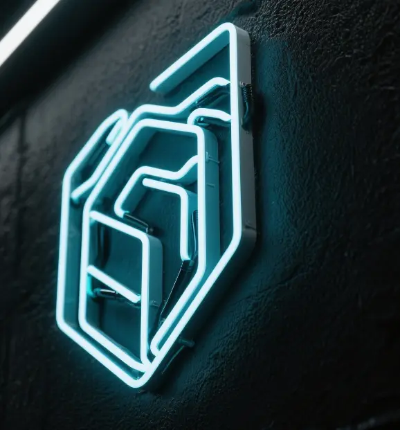 close-up of a futuristic neon logo glowing on a black wall